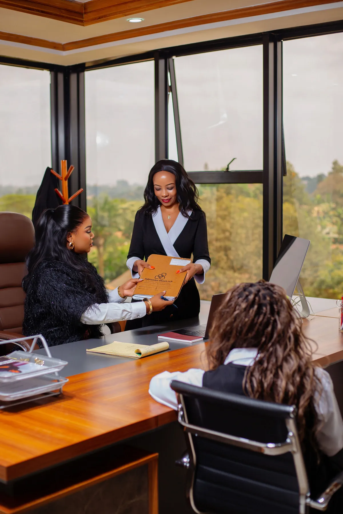 An advocate handing a client file across the desk